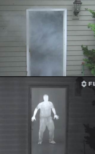 Image showing a smoke filled doorway and a person hiding behind, revealed by a FLIR LS Series thermal imaging camera